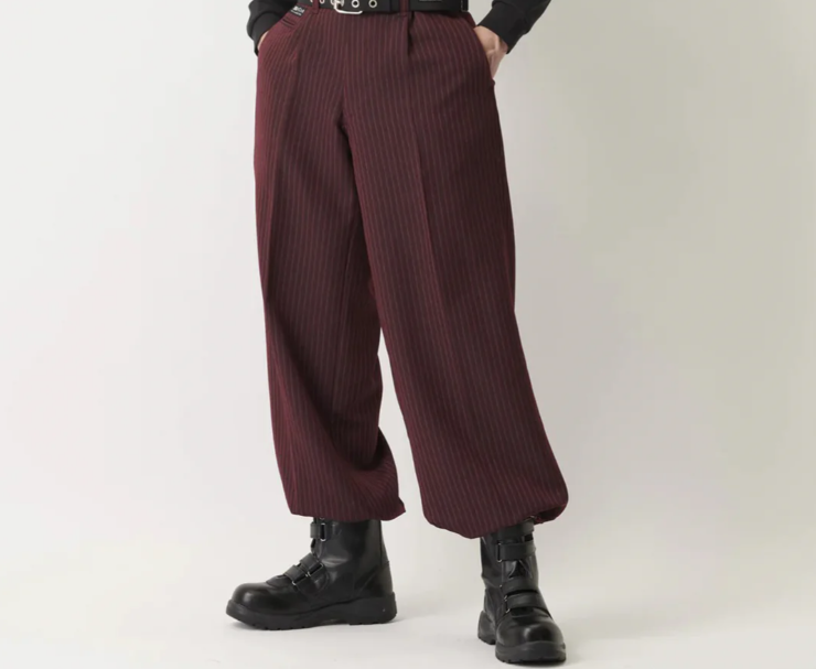 A model wearing burgundy pinstripe wide-leg Japanese work pants with a black belt and black work boots, shown against a plain light background.