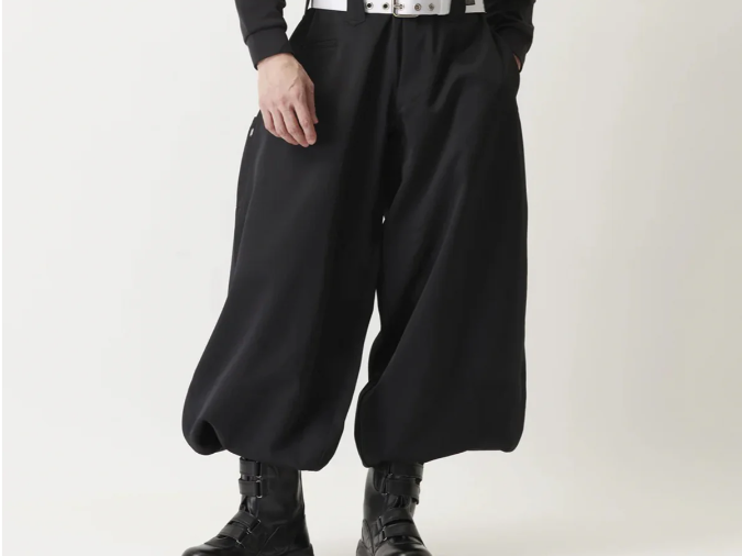 A model wearing black wide-leg Japanese tobi work pants with a white belt and black work boots, shown against a plain light background.