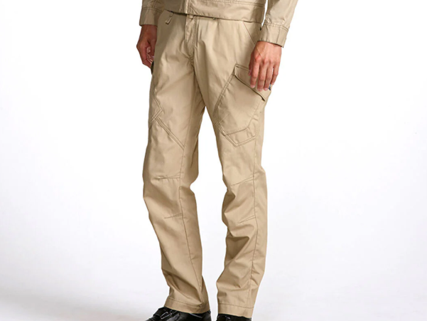A model wearing beige slim-fit work pants with reinforced paneling and side cargo pockets, shown against a light gray background.