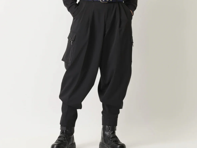A model wearing black tapered Japanese work pants with side cargo pockets, fitted cuffs, and black work boots, shown against a plain light background.
