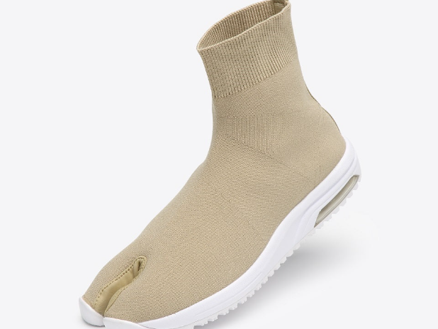 A beige split-toe knit work shoe with a sock-like upper and thick white sole, shown at an angle against a light gray background.