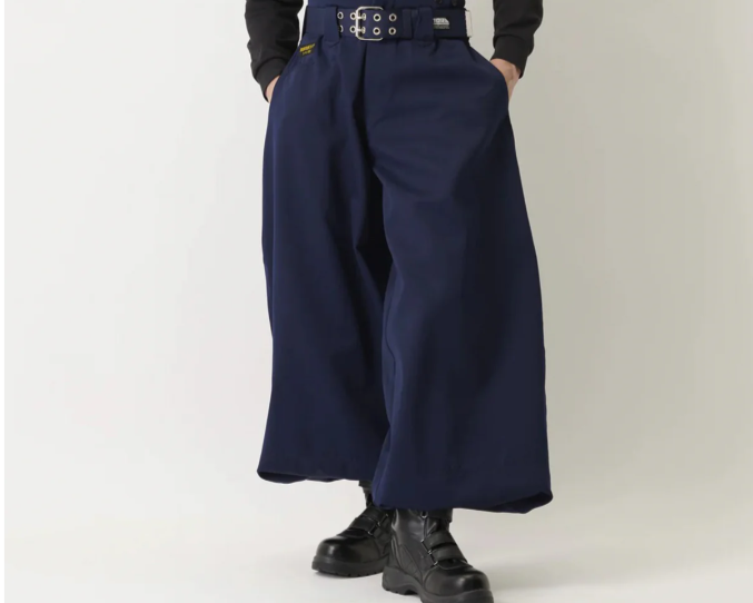 Model wearing navy wide-leg Japanese work pants with a high waist, black belt, and black boots against a plain studio background.