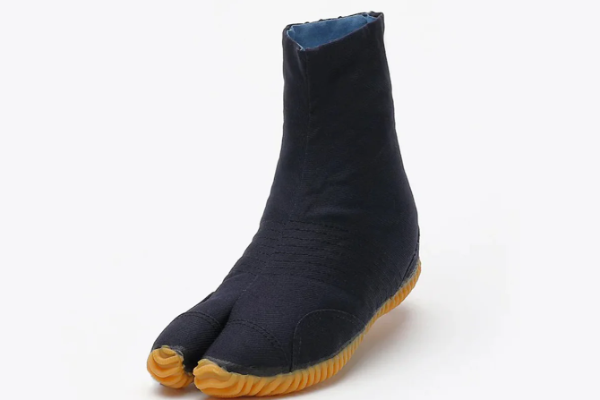 Black split-toe jikatabi boot with a blue inner lining and textured amber rubber sole on a plain white background.
