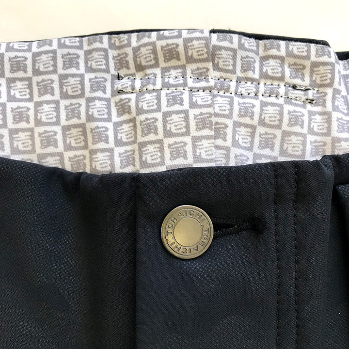 Lower leg taper detail of black Toraichi tobi pants with reflective bands