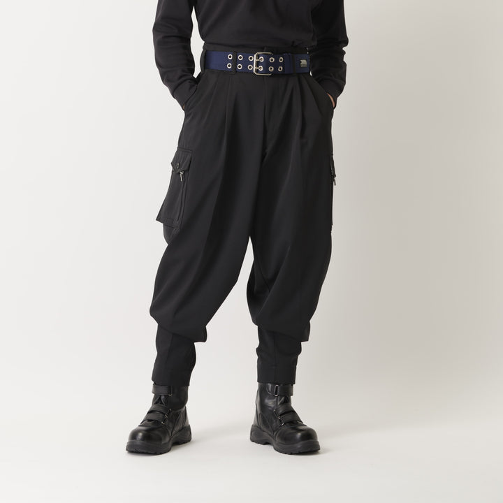 Model wearing black K-1 high-place work pants styled with a wide belt and boots