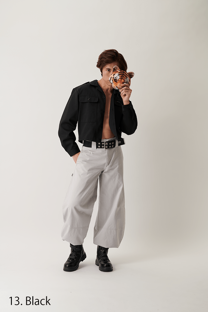 Model adjusting belt while wearing black short open shirt