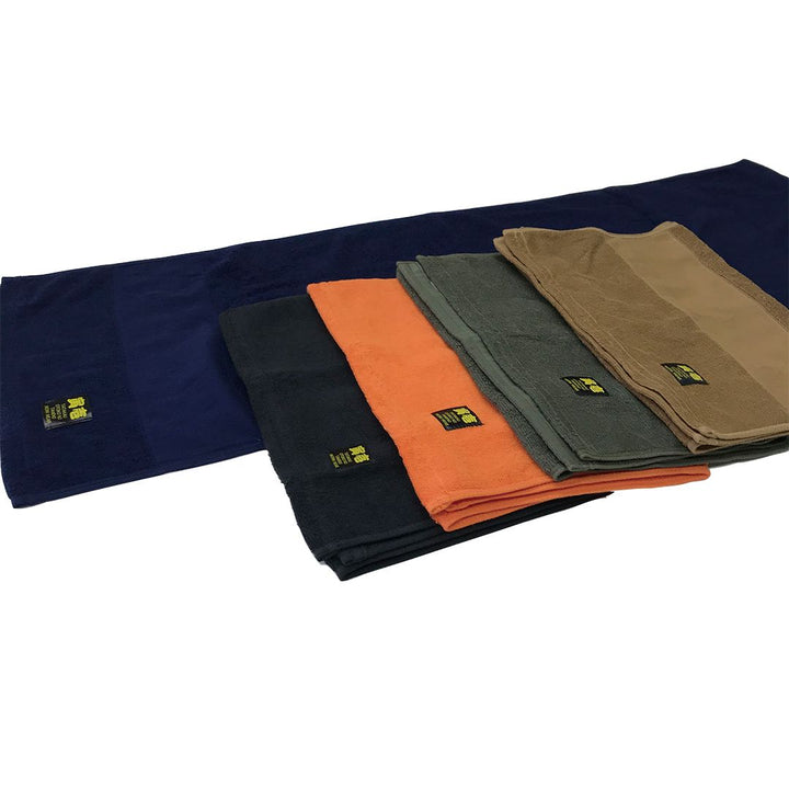 Layered arrangement of Toraichi towels displaying contrasting color combinations