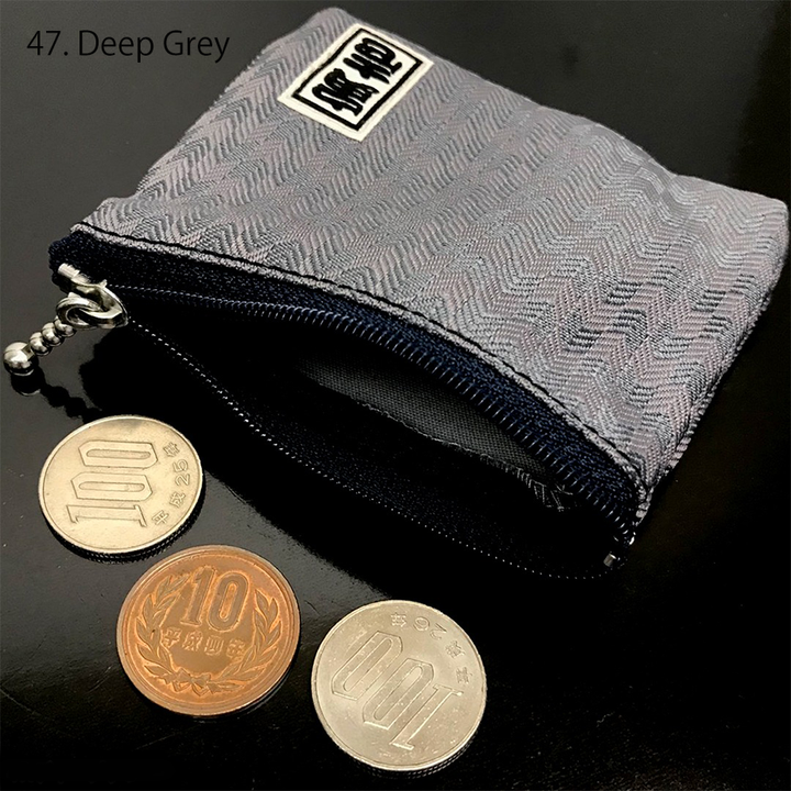 Top-down view of navy Toraichi coin purse with silver zipper pull