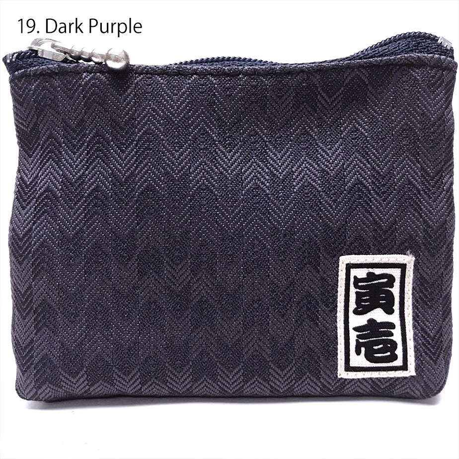 Navy Toraichi coin purse with brand label on black surface