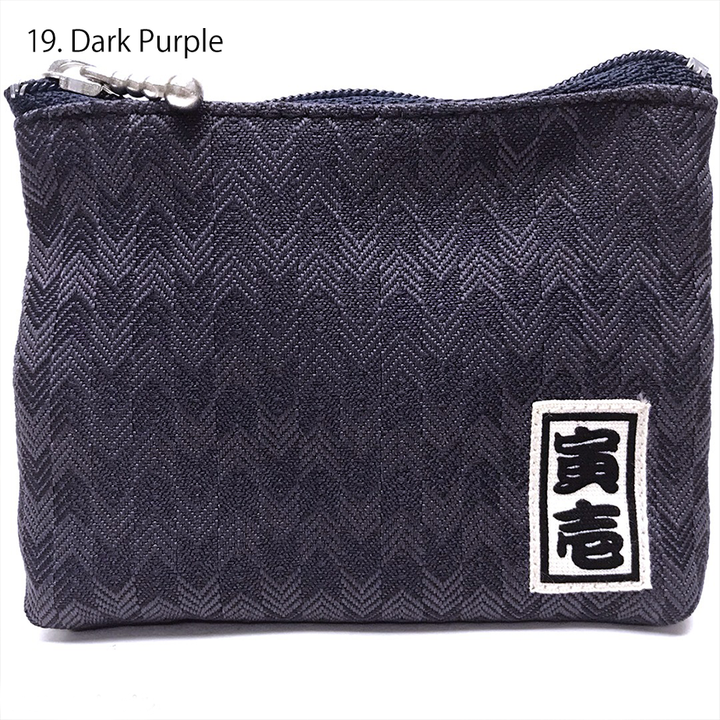 Navy Toraichi coin purse with brand label on black surface