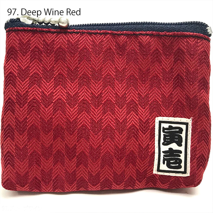 Black Toraichi coin purse showing textured weave and zipper edge